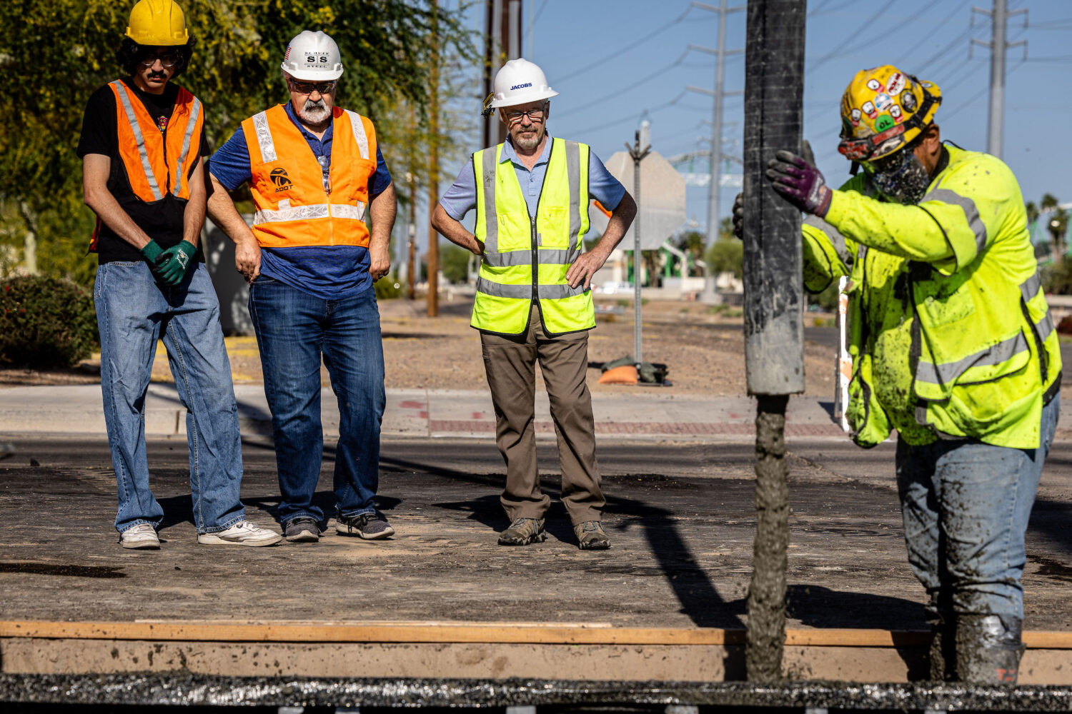 Workers watching the pouring of the last section of the northern spur of the Phoenix Valley Metro light rail extension. 