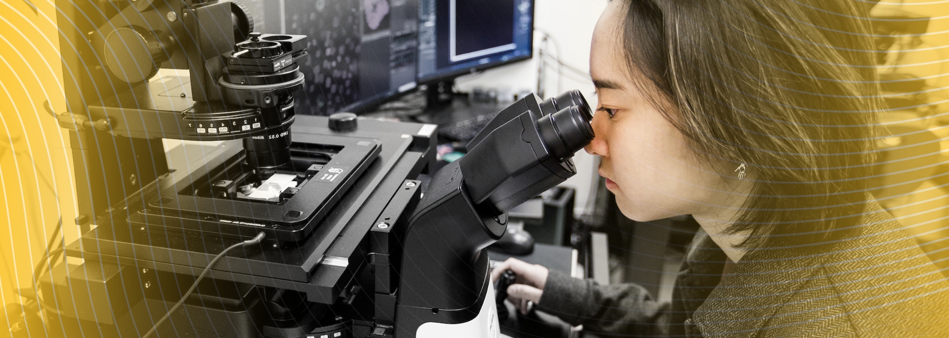 Student looking into microscope in lab